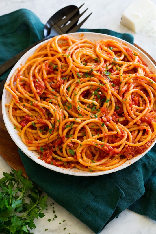 _*Bucatini all’Amatriciana*_ /Bucatini all’Amatriciana – A hearty and satisfying Italian dish made with bucatini pasta, rich pancetta or guanciale (an Italian pork), sharp Pecorino Romano cheese, and bright San Marzano tomatoes. It’s so simple to make and sure to satisfy those carb-y cravings!/ #Garlic #OliveOil #Onions #Pasta #RedPepperFlakes #RomanoCheese #Tomatoes Servings: 8 Ready in: 40 minutes Prep: 15 minutes Cook: 25 minutes Ingredients: 2 Tbsp extra virgin olive oil 6 oz. pancetta or guanciale, diced into tiny cubes (about 1/4-inch) 1 cup finely chopped yellow onion (1 small) 2 tsp minced garlic (2 cloves) 1 (28 oz) can San Marzano tomatoes, finely crushed in a bowl with your hands 1/3 cup dry white wine Salt and freshly ground black pepper 1/4 tsp red pepper flakes, or to taste 16 oz. dry bucatini pasta 3/4 cup finely shredded Pecorino Romano cheese 2 Tbsp minced parsley, for garnish (optional) Instructions: *1.* Bring a large pot of water to a boil. To cook pasta. *2.* Heat olive oil in a 12-inch saute pan over medium heat. Add pancetta and saute until golden brown, about 5 minutes. Transfer to a plate while leaving fat in pan. *3.* Return pan with fat medium heat, add onion and saute 3 minutes. Add garlic and saute 20 seconds longer. *4.* Pour in tomatoes, wine, red pepper flakes, cooked pancetta and season with pepper to taste. Bring to a simmer then reduce heat to low and let simmer about 15 to 20 minutes uncovered. *5.* Meanwhile boil pasta to al dente according to package directions in very lightly salted water (I only add 1/2 tsp). Reserve 1/2 cup pasta water before draining pasta. *6.* Toss drained pasta with the finished sauce and the Romano cheese. Taste for salt (it shouldn't need much because the pancetta is salty and the Romano). Thin with pasta water as needed. *7.* Serve right away garnished with parsley. https://www.cookingclassy.com/bucatini-amatriciana/