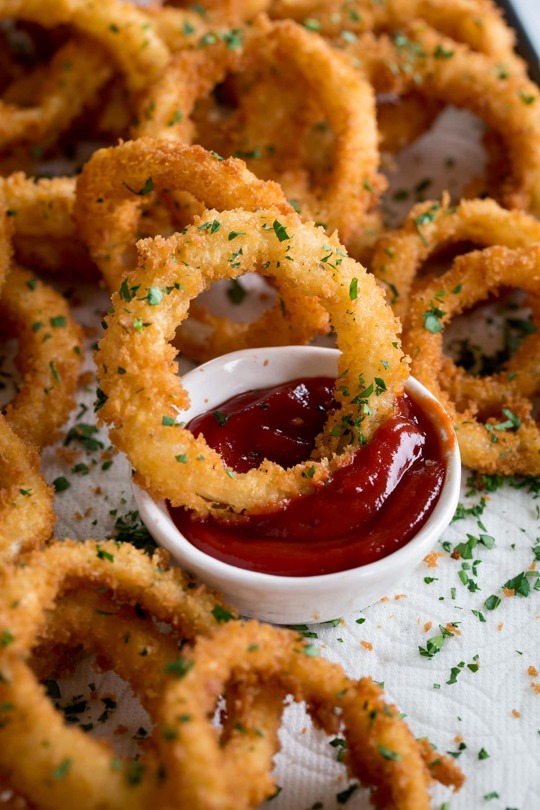_*Onion Rings*_ /They're extra crispy and deeply flavorful. Made with fresh yellow onion slices, a seasoned breading, and crunchy panko bread crumbs. It's a diner style cousin of french fries that's sure to satisfy!/ Makes approximately 50 onion rings.  Servings: 6 servings Ready in: 40 minutes Prep: 30 minutes Cook: 10 minutes  Ingredients:  2 large yellow onions (about 12 oz each), sliced 1/3 inch thick, separated into individual rings 1 cup (5 oz) all-purpose flour (scoop an level to measure) 1 tsp salt and 1/2 tsp pepper (or to taste) 3/4 tsp garlic powder 1/2 tsp paprika 1/2 tsp baking powder 1 cup buttermilk 1 large egg 2 1/2 cups Panko bread crumbs, or more if needed 6 cups vegetable oil or peanut oil, for fryingInstructions: *1.* Pour vegetable oil into a pot. Heat to 365 degrees over medium heat (and monitor temperature). Meanwhile prepare onion rings. *2.* In a shallow dish whisk together flour, salt, pepper, garlic powder, paprika and baking powder. *3.* Dredge onion rings in flour mixture, shake off excess (I just do two at a time and tap together to remove extra flour back into dish). Transfer onion rings to a baking sheet, reserve remaining flour mixture. *4.* In liquid measuring cup whisk together buttermilk and egg. Pour mixture into remaining flour mixture and whisk to blend (mixture should be similar to the consistency of pancake batter, if needed add a little more flour to thicken or buttermilk to thin). *5.* Pour panko into a separate shallow dish. *6.* Working with a few onion rings at a time, dip into batter mixture coating each side, shake excess batter back into dish, then transfer to panko and press and coat each side in panko. *7.* Transfer to preheated oil and fry until golden brown, turning halfway through frying (they should only take about 20 to 30 seconds per side). Fry in batches no more than 10 at a time to not overcrowd. *8.* Drain onto paper towel lined baking dish. Repeat process until all of the onion rings have been used up. *9.* Serve warm with ketchup or fry sauce if desired.  Notes: Nutrition estimate based on 6 Tbsp oil being absorbed. Serve with ketchup, fry sauce, ranch, or bbq sauce. For a homemade fry sauce mix 1/3 cup mayonnaise, 3 Tbsp ketchup, 3/4 tsp apple cider vinegar, and 2 pinches garlic powder and paprika. Season with salt and pepper to taste.  