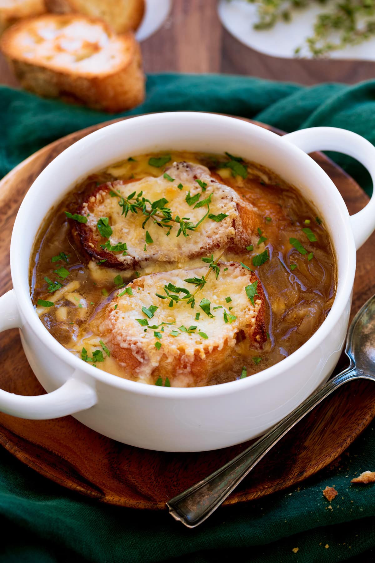 _*French Onion Soup*_ /The BEST French Onion Soup recipe! Made with slowly caramelized yellow onions, a savory lightly herby broth, and each serving is finished with golden brown, rich cheese toasts. Talk about delicious!/   #BayLeaves #BeefBroth #Bread #Butter #ChickenBroth #Garlic #GruyereCheese #Onions #ParmesanCheese #Thyme #WhiteWine  Servings: 6 Ingredients:  Soup 5 Tbsp unsalted butter, cut into 1-Tbsp pieces 3 lbs yellow onions (preferably larger), peeled and thinly sliced 1/4 tsp salt, then more to taste Water, as needed (up to about 1/2 cup) 2 Tbsp all-purpose flour 3/4 cup dry white wine, such as Sauvignon Blanc 4 cups beef stock 4 cups low-sodium chicken broth 1 large sprig thyme 2 bay leaves (fresh or dried) Cheese Toast 12 (3/4-inch slices) baguette (about 9 oz) 1 large garlic clove, halved 1 1/2 cups shredded gruyere cheese, or Swiss cheese 1/2 cup finely shredded parmesan cheese 1 Tbsp minced fresh parsley, optional  Instructions: *1.* Melt butter in a large pot* (about 6 quart) over medium heat.  *2.* Add onions and salt and saute tossing occasionally, for 45 to 50 minutes - but keep reading and proceed with sauteeing process as noted. For the first 15 minutes toss about every 3 to 4 minutes. Reduce burner temperature to medium-low if onions are browning too quickly or browning along bottom of pot.  *3.* From here you'll need to cook about 30 minutes longer, and start tossing the onions more frequently about every 2 minutes then even down to every minute. As you toss the onions throughout the entire sautéing and caramelization process use a wooden or bamboo spatula to scrape up light browned bits from bottom of pot.  *4.* Also as you notice any light browning on the bottom of the pot that doesn't scrape up scoot the onions from that area, add a splash of water (about 1 Tbsp) then let it steam and scrape with the spatula (it can be scrapped into the onion mixture). This will really keep onion soup from tasting burnt.  *5.* Once onions are caramelized add flour and saute 1 minute.  *6.* Pour in white wine and scape up golden brown bits from bottom, and stir well to smoothly incorporate flour. Add beef stock, chicken broth, thyme and bay leaves, salt and pepper to taste and bring to a simmer over medium-high heat.  *7.* Reduce heat to low, cover and simmer 15 to 20 minutes.  *8.* Meanwhile move oven rack about 6 inches from top element and preheat oven to 450 degrees. Rub garlic halves over one side of each baguette slice then align on a 18 by 13-inch rimmed baking sheet. Bake in preheated oven until slightly golden brown and crisp about 5 to 8 minutes.  *9.* Once soup is done, remove thyme and bay leaves.  *10.* Preheat the oven to broil. Ladle soup into broil proof bowls filling no more than about 2/3 full (I used 20 oz bowls and added 1 1/2 cups soup).  *11.* Working with up to 4 bowls at a time place them on rimmed baking sheet (same one used to toast bread) top each soup with two baguette slices.  *12.* Sprinkle with plenty of the gruyere and parmesan cheese then place about 6 inches from boiler (still set on baking sheet) and broil until cheese is nicely melted.  *13.* Serve right away garnished with parley if desired.   Notes: I recommend using a heavy pot with a light colored interior so you can see when there is excess browning on the bottom of the pot to deglaze. I prefer an enameled cast iron pot rather than stainless steel or non-stick, onions don't burn as easily. Recipe makes about 9 cups.  https://www.cookingclassy.com/french-onion-soup/