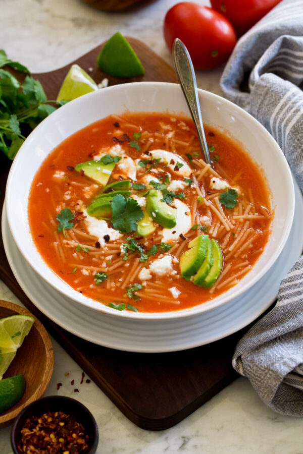 _*Sopa de Fideo*_ /An incredibly easy Mexican soup made with a few basic ingredients including toasted pasta, fresh tomatoes, onion, garlic, and broth. Once finished it’s garnished with desired toppings to build up delicious layers of flavor./   #Avocado #ChickenBroth #Cilantro #Garlic #Limes #OliveOil #Onion #QuesoFresco #Tomatoes  Servings: 5 Ready in: 45 minutes Prep: 15 minutes Cook: 30 minutes  Ingredients:  1 1/2 lbs roma tomatoes, halved 1 small yellow onion, peeled and halved 3 medium garlic cloves, peeled 3 Tbsp olive oil 1 (7 to 8 oz) pkg. fideo 5 cups low-sodium chicken broth Salt and black pepper Toppings 3 Tbsp chopped cilantro 5 Lime wedges 1/2 cup Queso fresco cheese, crumbled (optional) Mexican crema or sour cream (optional) Cumin, ancho chili powder, red pepper flakes (optional) 1 avocado, diced (optional)  Instructions: *1.* Add tomatoes, onion, and garlic to a blender. Cover and blend until pureed. Set aside.  *2.* Heat olive oil in a large pot over medium heat. Add fideo and saute, tossing constantly with a rubber spatula, until golden brown, about 3 to 5 minutes (reduce heat slightly if needed if it's browning too quickly).  *3.* Pour in chicken broth and tomato mixture. Season with salt and pepper to taste.  *4.* Bring mixture to a simmer then reduce heat to low and simmer, uncovered, until pasta is tender, about 15 minutes.  *5.* Ladle soup into bowls and finish with toppings and serve with lime wedges for spritzing over.   Notes: Soup can be thinned with more broth as desired. Note that it will thicken as it rests and the pasta absorbs more broth. Optional toppings not included in nutritional estimate.  https://www.cookingclassy.com/sopa-de-fideo/