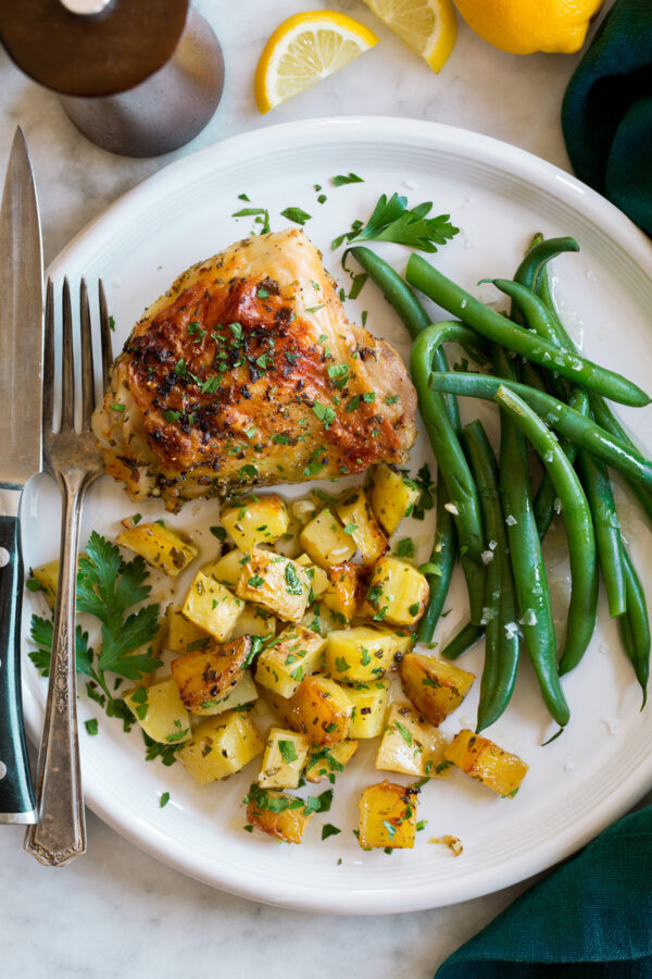 _*Baked Lemon Chicken and Potatoes*_ /A vibrant chicken and potatoes recipe! Yukon gold potatoes and hearty chicken thighs are tossed with a lemon, garlic, and herb seasoned oil and baked on a single sheet pan until browned, tender and distinctively delicious!/ #ChickenThighs #Garlic #Lemons #OliveOil #Parsley #Potatoes #Rosemary #Thyme Servings: 6 Ready in: 1 hour 5 minutes Prep: 20 minutes Cook: 45 minutes Ingredients: 6 large (7 oz each) bone-in skin-on chicken thighs 1/4 cup olive oil 1 Tbsp lemon zest 1/4 cup lemon juice 2 Tbsp minced garlic 1 Tbsp chopped fresh thyme 1 Tbsp chopped fresh rosemary or oregano 5 Tbsp chopped fresh parsley, divided Salt and freshly ground black pepper 2 1/2 lbs Yukon gold potatoes, cut into 2/3-inch cubes Instructions: *1.* Move oven rack up one level from center. Preheat oven to 400 degrees and spray a rimmed 18 by 13-inch baking sheet with non-stick cooking spray (preferably use a dark coated baking sheet to encourage browning). *2.* In a small mixing bowl whisk together olive oil, lemon zest, lemon juice, garlic, thyme, rosemary, and 3 Tbsp parsley. *3.* Place potatoes in a large mixing bowl then pour or spoon half the herb mixture over the potatoes. Toss to evenly coat, season with salt and pepper to taste and toss. *4.* Spread potatoes evenly over prepared baking sheet. *5.* Place chicken in now empty large mixing bowl, pour remaining half of the herb mixture over chicken and toss to evenly coat. Season both sides of thighs with salt and pepper and place evenly over potato layer on baking sheet. *6.* Bake in preheated oven until chicken is cooked through and potatoes are tender, about for 45 minutes. For more browned chicken broil during the last few minutes. *7.* If you find the chicken is done earlier than the potatoes you can remove chicken to a plate and continue to bake potatoes until soft. *8.* Remove from oven and sprinkle remaining parsley over everything and serve. Notes: Note that lemon slices weren't added during baking only used for garnish (I don't like the bitter flavor the white pith of the peel imparts when cooking). https://www.cookingclassy.com/baked-lemon-chicken-and-potatoes-recipe/