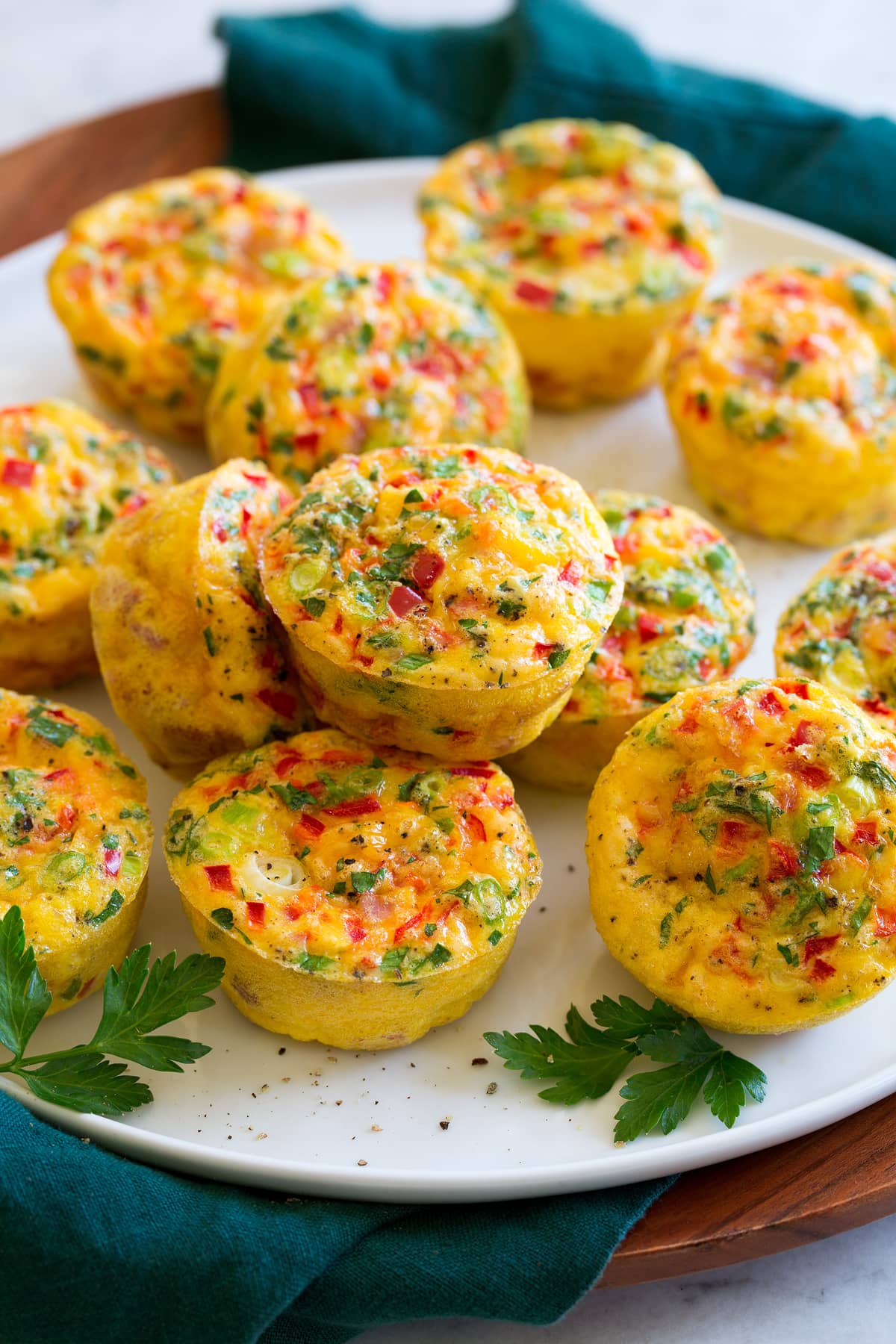 _*Breakfast Egg Muffins*_ /An easy breakfast recipe made with hearty eggs and an abundance of delicious mix-ins. They’re like mini individual frittatas and they're the perfect on the go breakfast./   #BellPepper #CheddarCheese #Eggs #GreenOnions #HalfAndHalf #Ham #Parsley  Servings: 12 Ready in: 35 minutes Prep: 15 minutes Cook: 20 minutes  Ingredients:  10 large eggs 1/3 cup half and half 1 cup (heaping) small diced cooked ham 3/4 cup finely chopped red bell pepper 2/3 cup shredded sharp cheddar cheese 1/4 cup chopped green onions (thinly slice white portion) 2 Tbsp chopped fresh parsley 1/4 tsp salt, or to taste 1/2 tsp black pepper  Instructions: *1.* Preheat oven to 375 degrees. *2.* Crack eggs into a large mixing bowl and add half and half. Using a fork pierce the yolks then whisk with the fork until mixture is just combined. *3.* Add ham, bell pepper, cheddar, green onions, parsley, salt and pepper. Stir with the fork to mix. *4.* Spray a 12-cup muffin pan well with non-stick cooking spray. Fill each with 1/3 cup of the mixture (filling nearly to the top. Scoop near the bottom of the bowl with the measuring cup to get some of the mix-ins in each measurement). *5.* Bake in preheated oven until eggs are just barely set, about 19 - 23 minutes. *6.* Let cool in pan about 5 minutes then serve, or cool on a wire rack about 30 minutes before storing in the fridge or freezer.  Notes: You can change up the mix-ins as you'd like adding up to 3 cups max. Other good options include Cooked sausage or chorizo Cooked bacon Feta or Swiss cheese Cilantro, basil or dill or chives Other types of peppers such as poblano or Hatch Diced tomatoes Sauteed mushrooms or spinach