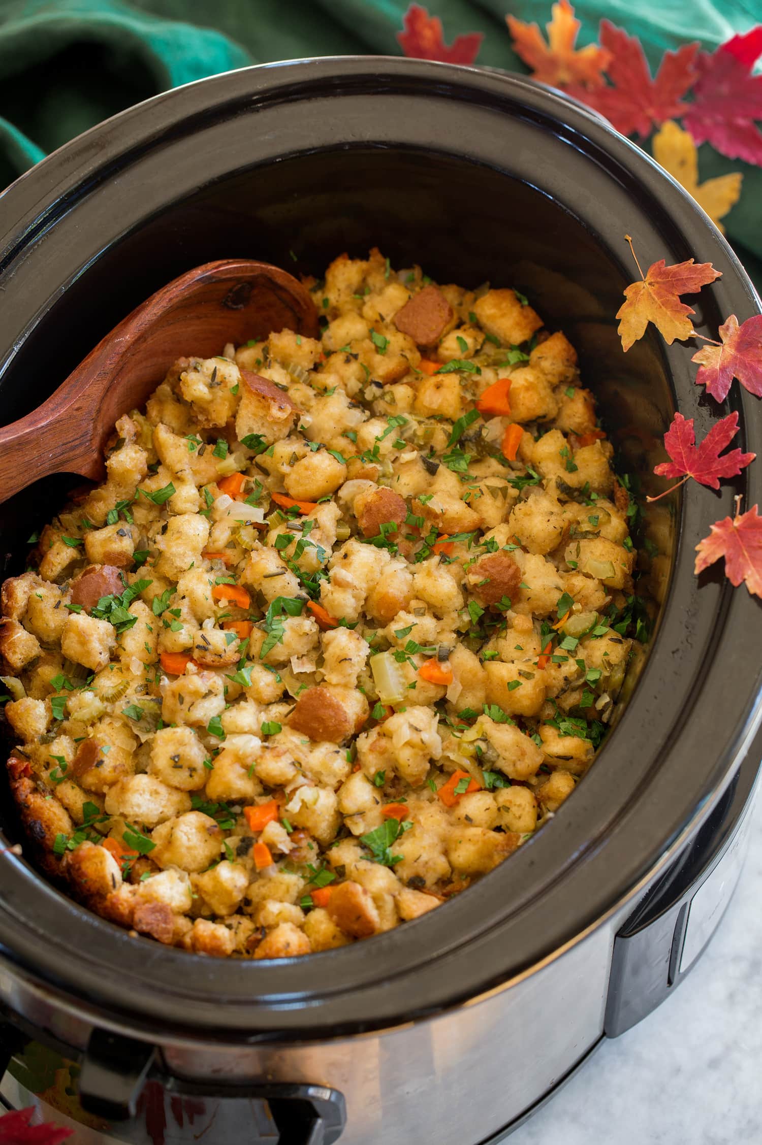 _*Crockpot Stuffing*_ /This is a family favorite and may likely become your go-to Thanksgiving stuffing recipe too. It has the perfect amount of buttery moisture, crisp golden brown edges, and a delicious herby flavor. Plus this slow cooker method frees up oven space. It's the perfect stuffing!/ #Bread #Butter #Carrots #Celery #ChickenBroth #Eggs #Garlic #Marjoram #Onions #Parsley #PoultrySeasoning #Sage #Thyme Servings: 12 Ready in: 5 hours 30 minutes Prep: 30 minutes Cook: 5 hours Ingredients: 2 lbs hearty white sandwich bread*, diced into pieces between 1/2 and 3/4-inch thick, or 15 cups store-bought dried unseasoned bread cubes 2 - 3 1/2 cups low-sodium chicken broth, as needed 2 large eggs 1 tsp poultry seasoning 1 tsp salt, or to taste 1/2 tsp freshly ground black pepper, or to taste 3/4 cup unsalted butter, diced into 1 Tbsp pieces 2 cups chopped yellow onion 2 cups chopped celery 1 cup chopped carrot (dice small) 1 large clove garlic, minced 1/4 cup chopped fresh parsley, plus more for garnish 2 1/2 Tbsp chopped fresh sage (or 2 1/2 tsp dried) 1 Tbsp chopped fresh thyme (or 1 tsp dried) 1 Tbsp chopped fresh marjoram (or 1 tsp dried) 2 tsp chopped fresh rosemary (or 1/2 tsp dried, crushed) Instructions: *1.* Preheat oven to 275 degrees. Spread bread cubes evenly onto 2 rimmed baking sheets. *2.* Bake in preheated oven on alternating oven racks, until bread cubes are dried, while rotating baking sheets and also removing from oven and tossing bread cubes occasionally, about 45 - 55 minutes. *3.* Remove from oven and allow to cool.** *4.* In a bowl mix together 2 cups of the chicken broth with the eggs, poultry seasoning, salt and pepper until well blended. *5.* Pour dried bread cubes (I had 17 cups) into a very large mixing bowl. *6.* Melt butter in a large non-stick skillet over medium-high heat. Add onion, celery and carrot and saute until soft, about 8 - 12 minutes, adding in garlic during last minute of sauteing. *7.* Pour onion mixture, along with parsley, sage, thyme, marjoram and rosemary over bread cubes in mixing bowl and immediately toss. *8.* Evenly drizzle chicken broth mixture over top and immediately toss to evenly coat. Add in more broth just as needed to moisten bread.*** *9.* Spray a 6-quart slow cooker with non-stick cooking spray then pour bread cube mixture into slow cooker. *10.* Cover and cook on high heat 30 minutes then reduce heat to low and cook 3 1/2 - 5 hours longer. Sprinkle top with more fresh parsley (about 1 Tbsp) and serve warm. Notes: If using store-bought dried bread skip the drying in oven step. I recommend doing this step (drying bread cubes) a day or two before and storing cooled bread cubes in a gallon size resealable bags. You don't want the bread cubes soaked or it will end up soggy, the bread should hold it shape and doesn't need to be entirely moistened all the way through, I used about 2 1/2 cups. Recipe makes about 12 cups.