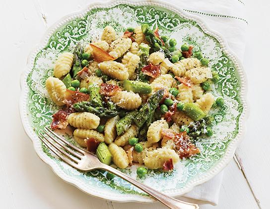 _*Fresh Asparagus and Peas with Gnocchi*_ /Celebrate spring with farm-fresh Ontario asparagus and sweet peas tossed with tender potato gnocchi and crisp bacon – who can resist?/   #Dinner #MainDishes #CalendarRecipe  minutes: 4-6 Preparation Time: 10 minutes Cooking Time: 15 minutes  Ingredients:  3 strips Ontario Bacon 1 lb (500 g) Ontario Asparagus, trimmed and cut into pieces 1/2 cup (125 mL) chopped Ontario Shallots 3 cloves Ontario Garlic, minced 1/4 tsp (1 mL) each salt and pepper 1 lb (500 g) potato gnocchi (fresh, frozen or shelf-stable) 1/2 cup (125 mL) fresh Ontario Peas 3 tbsp (45 mL) grated Parmesan cheese  Instructions: *1.* In large skillet, cook bacon on medium-high heat, turning once, until crisp. Transfer to paper towel-lined plate; set aside. Reserve 1 tbsp (15 mL) of the fat from skillet. Wash skillet.  *2.* Add reserved fat, asparagus, shallots, garlic, salt and pepper to clean skillet; cook, stirring often, until asparagus is tender-crisp, about 7 minutes.  *3.* Meanwhile, in large pot of boiling lightly salted water, cook gnocchi according to package directions, adding peas for the last 2 minutes of cooking time. Drain, reserving 1/2 cup (125 mL) of the cooking water.  *4.* Crumble bacon and add half to skillet along with reserved cooking water, gnocchi mixture and 2 tbsp (25 mL) of the Parmesan cheese; toss to coat. Spoon into serving dish. Sprinkle with remaining bacon and cheese.   Tips: No shallots? Simply use a small Ontario onion.   If fresh peas are not available, use frozen Ontario peas. Potato gnocchi are small dumplings; look for them at the supermarket in the deli section with the fresh pasta in vacuum packs, with the dry pasta or in the freezer section.