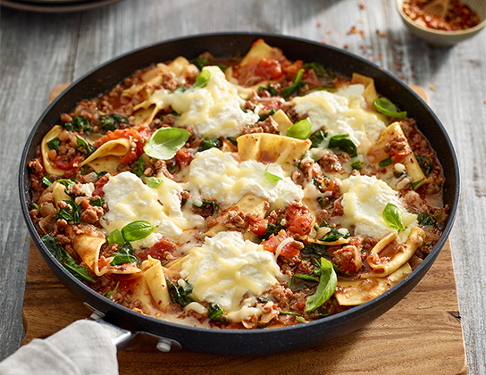 _*Lamb Skillet Lasagna*_ /Take your lasagna to the skillet with this rustic deconstructed lasagna. Ontario lamb adds a wonderful richness to the sauce and becomes creamy with the addition of Ontario ricotta and mozzarella cheeses. Dinner is ready!/   #Dinner #MainDishes #CalendarRecipe  Serves: 4 to 6 Preparation Time: 20 minutes Cooking Time: 20 minutes  Ingredients:  4 fresh lasagna sheets 1 tbsp (15 mL) vegetable oil 3 cloves garlic, minced 1 Ontario Onion, diced 500 g ground Ontario Lamb 1 tbsp (15 mL) dried oregano leaves 1/2 tsp (2 mL) salt  1/4 tsp (1 mL) crushed red pepper flakes 1 can (19 oz/540 mL) petite cut stewed tomatoes with juices 1 cup (250 mL) beef or chicken broth  4 cups (1 L) Ontario Baby Spinach  1 cup (250 mL) Ontario Ricotta Cheese 3/4 cup (175 mL) shredded Ontario Mozzarella Cheese 3 tbsp (45 mL) chopped fresh Ontario Basil Leaves    Instructions: *1.* Cut lasagna sheets in half crosswise, then cut into 1-1/2 inch (4 cm) wide strips. Set aside.  *2.* In large nonstick deep skillet, heat oil over medium heat. Cook garlic and onion for 3 minutes or until softened. Add lamb, oregano, salt and red pepper flakes; cook, stirring for 5 minutes or until lamb is no longer pink.   *3.* Add tomatoes and broth to lamb mixture; bring to boil. Stir in spinach and pasta; return to simmer. Cover; cook for 10 minutes or until pasta is tender. Uncover, dollop with ricotta and sprinkle with mozzarella; cook for about 2 minutes to heat ricotta and melt cheese. Sprinkle with basil.