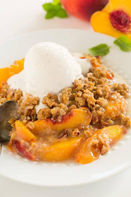 _*Peach Crisp*_ /It’s true, this is no doubt the best peach crisp I’ve ever had! I’m completely in love with it! I couldn’t stop reaching for just one more bite, and then another, and oh just one last little one./ /Take a look at all these layers and tell me how you could resist?/ #BrownSugar #Cinnamon #Flour #Ginger #Hazelnuts #LemonJuice #Nutmeg #Oats #Peaches #Pecans #Sugar Servings: 7 Ready in: 1: hour hour Prep: 20 minutes Cook: 40 minutes Ingredients: Peach Filling 3 lbs fresh peaches , cored and sliced into wedges 3/4-inch thick 1 Tbsp fresh lemon juice 1/4 cup granulated sugar 2 Tbsp all-purpose flour Topping 3/4 cup all-purpose flour 3/4 cup old-fashioned oats 1/4 tsp salt 3/4 tsp ground cinnamon 1/8 tsp ground nutmeg 1/8 tsp ground ginger 3/4 cup packed light-brown sugar 10 Tbsp unsalted butter , cold and diced into 1/2-inch cubes 1/2 cup chopped pecans or hazelnuts (I used half of each. Chop them small) Instructions: *1.* Preheat oven to 350 degrees. In a large mixing bowl toss peaches with lemon juice. Sprinkle granulated sugar and flour over top and toss to evenly coat. Pour mixture into a buttered 3 quart baking dish (mine was 12 x 8 x 2 1/2) and set aside. *2.* In a mixing bowl, whisk together flour, oats, salt, cinnamon, nutmeg and ginger. Add brown sugar and stir, while using fingertips to break up any clumps. *3.* Add butter to mixture and using fingertips, rub into mixture until it comes together in small clumps and pieces of butter a no longer visible. *4.* Mix in nuts, tossing several times (so it sticks to the crumble). Sprinkle mixture evenly over top of peaches in baking dish. *5.* Bake in preheated oven about 38 - 42 minutes until topping is golden brown and juices are bubbling along edges. Serve warm with ice cream or sweetened whipped cream if desired