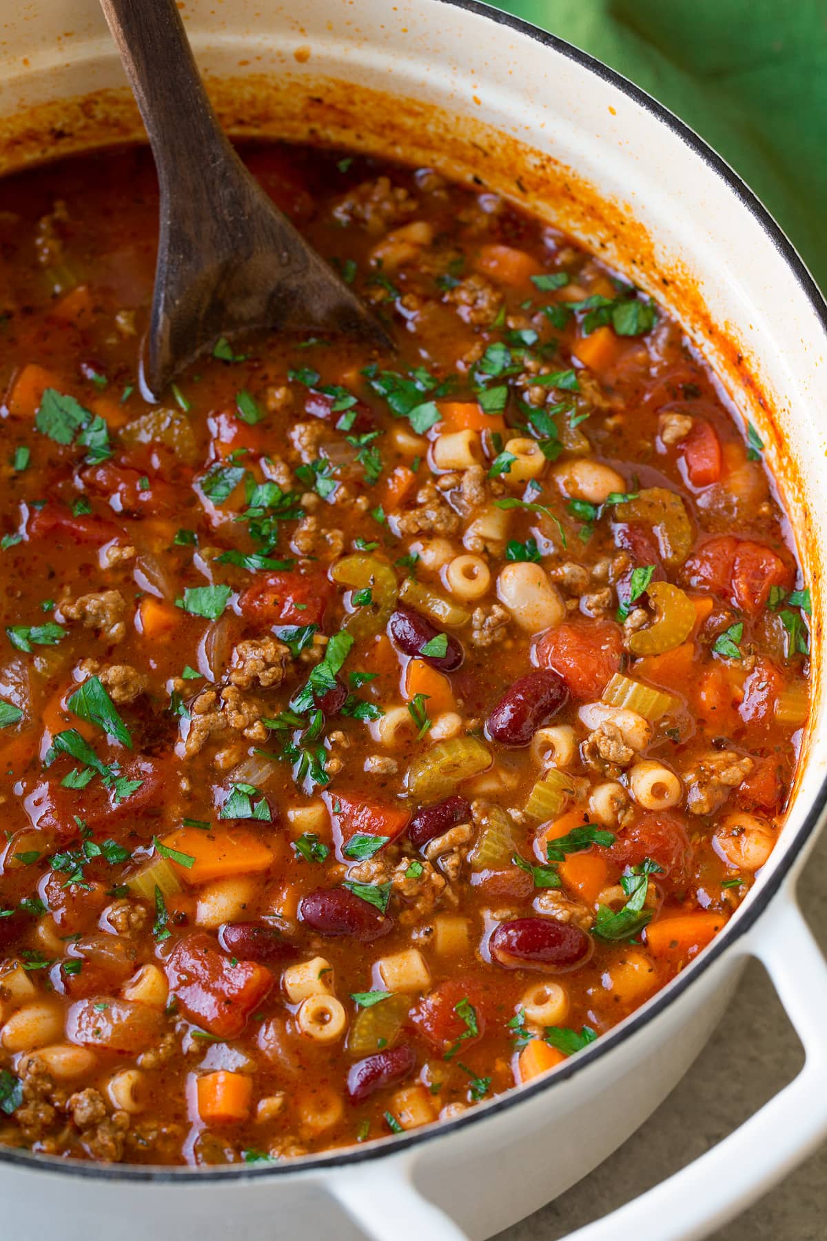_*Pasta e Fagioli Soup {Better than Olive Garden’s}*_ /This Pasta e Fagioli is one of my all time favorite soups and one of my most popular recipes! It's loaded with vegetables and brimming with Italian flavor. It's perfectly comforting, hearty and absolutely delicious!/   #PastaFagioli #FallFaves #MainDish #Soups #Videos #Beef #Carrots #Celery #KidneyBeans #NavyBeans #Pasta #Tomatoes  Prep: 15 minutes. Cook: 35 minutes. Ready in: 50 minutes.  INGREDIENTS: 1: 2 Tbsp olive oil, divided. 2: 1 lb lean ground beef. 3: 1 1/2 cups chopped yellow onion. 4: 1 cup diced carrots (about 2 medium). 5: 1 cup diced celery (about 3 stalks). 6: 3 cloves garlic, minced (1 Tbsp). 7: 3 (8 oz) cans tomato sauce. 8: 2 14.5 oz cans low-sodium chicken broth. 9: 1/2 cup water, then more as desired. 10: 1 (15 oz) can diced tomatoes. 11: 2 tsp granulated sugar. 12: 1 1/2 tsp dried basil. 13: 1 tsp dried oregano. 14: 3/4 tsp dried thyme. 15: 1/2 tsp dried marjoram. 16: Salt and freshly ground black pepper. 17: 1 cup dry ditalini pasta. 18: 1 (15 oz) can dark red kidney beans, drained and rinsed. 19: 1 (15 oz) can great northern beans, drained and rinsed. 20: Finely shredded Romano or Parmesan cheese , for serving. 21: 3 Tbsp minced fresh parsley.  INSTRUCTIONS:  1: Heat 1 Tbsp olive oil in a large pot over medium high heat, crumble in ground beef and cook, stirring occasionally until cooked through. 2: Drain fat from beef then transfer beef to a plate, set aside.  Heat remaining 1 Tbsp olive oil in same pot. 3: Add onions, carrots, and celery and saute over medium-high heat until tender about 6 minutes, add garlic and saute 1 minute longer. 4: Add chicken broth, tomato sauce, water, canned tomatoes, sugar, basil, oregano, thyme, marjoram and cooked beef then season with salt and pepper to taste. 5: Bring to a boil then reduce heat to medium-low, cover with lid and allow to simmer, stirring occasionally, until veggies are soft, about 15 - 20 minutes. 6: Meanwhile prepare ditalani pasta according to directions on package, cooking to al dente. 7: Add cooked and drained pasta to soup* along with kidney beans and great northern beans. Thin with a little more broth or water if desired. 8: Allow to cook 1 minute longer. Stir in parsley, serve warm with grated Romano or Parmesan cheese. Notes: *If you don't plan on eating all of the soup right away I recommend adding the pasta to individual servings. Otherwise pasta gets soggy and absorbs too much broth.