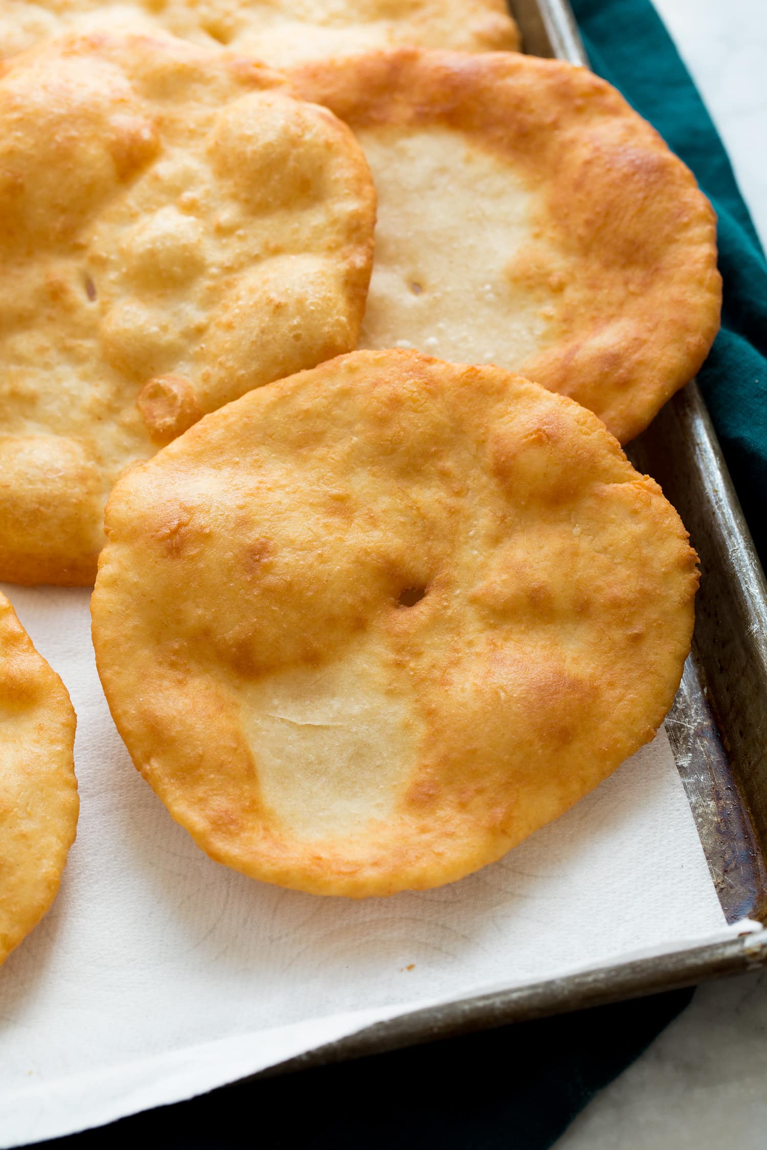 _*Fry Bread*_ /Homemade Navajo Fry Bread! This is pillowy soft on the inside lightly crisp and beautifully golden brown on the outside and each tender bite just melts in your mouth! They're the perfect base for Navajo tacos or they make an excellent dessert when smothered with sweet honey butter./   #Butter #Flour #Milk #VegetableOil #Yeast  Servings: 8 Ingredients:  2 1/4 cups (381g) all-purpose flour 2 tsp baking powder 1/2 tsp instant yeast or rapid rise yeast 1/2 tsp salt 1 cup warm milk (heat to 110 degrees), plus more milk as needed 1 Tbsp butter, melted Vegetable oil for frying (about 3 to 4 cups)  Instructions: *1.* In a mixing bowl, whisk together flour, baking powder, yeast and salt, make a well in center of mixture. Whisk melted butter and warm milk together and pour milk mixture into dry ingredients.  *2.* Stir with a wooden spoon until mixture comes together and forms a rough ball, dough should be fairly sticky. If needed you can add an additional 1 - 2 Tbsp milk (cold milk is fine) to reach a good consistency but try not to overwork the dough).  *3.* Cover dough with plastic wrap and let rest 10 minutes.  *4.* Heat 1-inch of vegetable oil in a large saucepan over medium heat. Heat to 360 degrees F°.  *5.* Divide rested dough into 8 equal pieces. Line a baking sheet with paper towels, set aside.  *6.* Working with floured hands and one piece of dough at a time (keep other pieces covered with plastic wrap), roll dough or pat dough out on a lightly floured surface into a 6-inch circle (for fry bread to cook more evenly you can make poke a small hole in the center of the dough which helps it not inflate excessively in the center).  *7.* Carefully add rolled out fry bread into hot oil, and cook until golden brown, then flip and cook opposite side until golden brown (this usually takes about 30 seconds per side though the second side tends to cook faster). Lift with tongs and let excess oil drain off back into pan.  *8.* Transfer to paper towel lined baking sheet to drain. Repeat process with remaining fry bread dough while monitoring oil temp to keep close to 360 degrees F°.   Notes: Nutrition estimate based on 1/4 cup vegetable oil being absorbed total.
