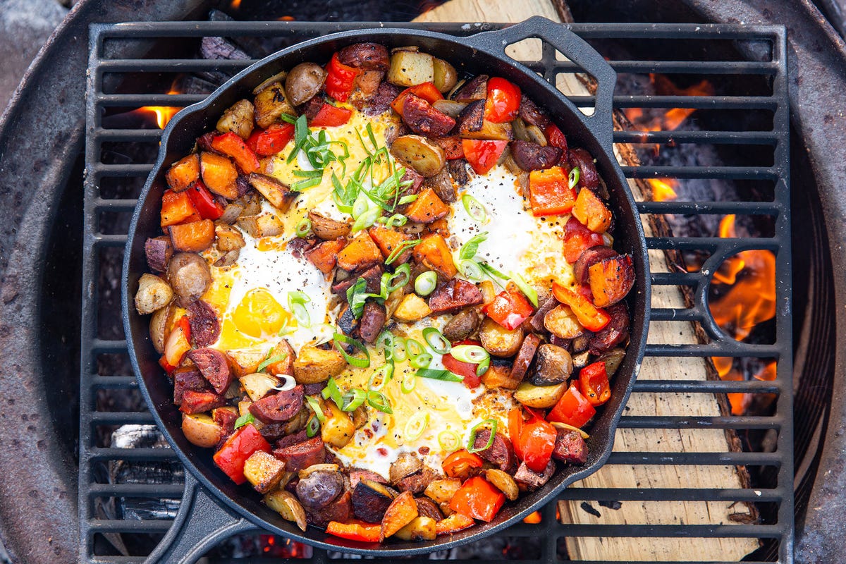 _*Maple Chorizo Breakfast Skillet*_ /If you thought maple syrup-drenched bacon was good, wait until you try maple chorizo. The smoky-sweet combo will haunt your dreams. Not camping? This recipe works great over a grill./    YIELDS: 2 - 4 TOTAL TIME: 30 mins Ingredients:  2 tbsp. extra-virgin olive oil 1 1/2 lb. potatoes, scrubbed clean and diced into ½" pieces Kosher salt Freshly ground black pepper 1 large bell pepper, chopped 1 medium yellow onion, chopped 8 oz. cured (not fresh) Spanish chorizo, diced 2 tbsp. maple syrup 4 to 6 large eggs  Sliced green onions, for garnish  Directions: Step 1 Place a grate and large cast-iron skillet over a campfire and preheat 15 minutes. Heat oil in skillet, then add potatoes in an even layer. Season with salt and pepper and cook, undisturbed, until golden and crispy on one side, 3 to 4 minutes.  Step 2 Stir in peppers, onions, chorizo, and maple syrup. Cook, stirring occasionally, until potatoes are tender, 10 to 12 minutes.  Step 3 Use a spoon to make wells in mixture. Crack an egg into each well and season with salt and pepper. Cover skillet with foil (or a lid) and cook until eggs are done to your liking, 3 to 4 minutes.  Step 4 Garnish with green onions and season with more black pepper before serving.