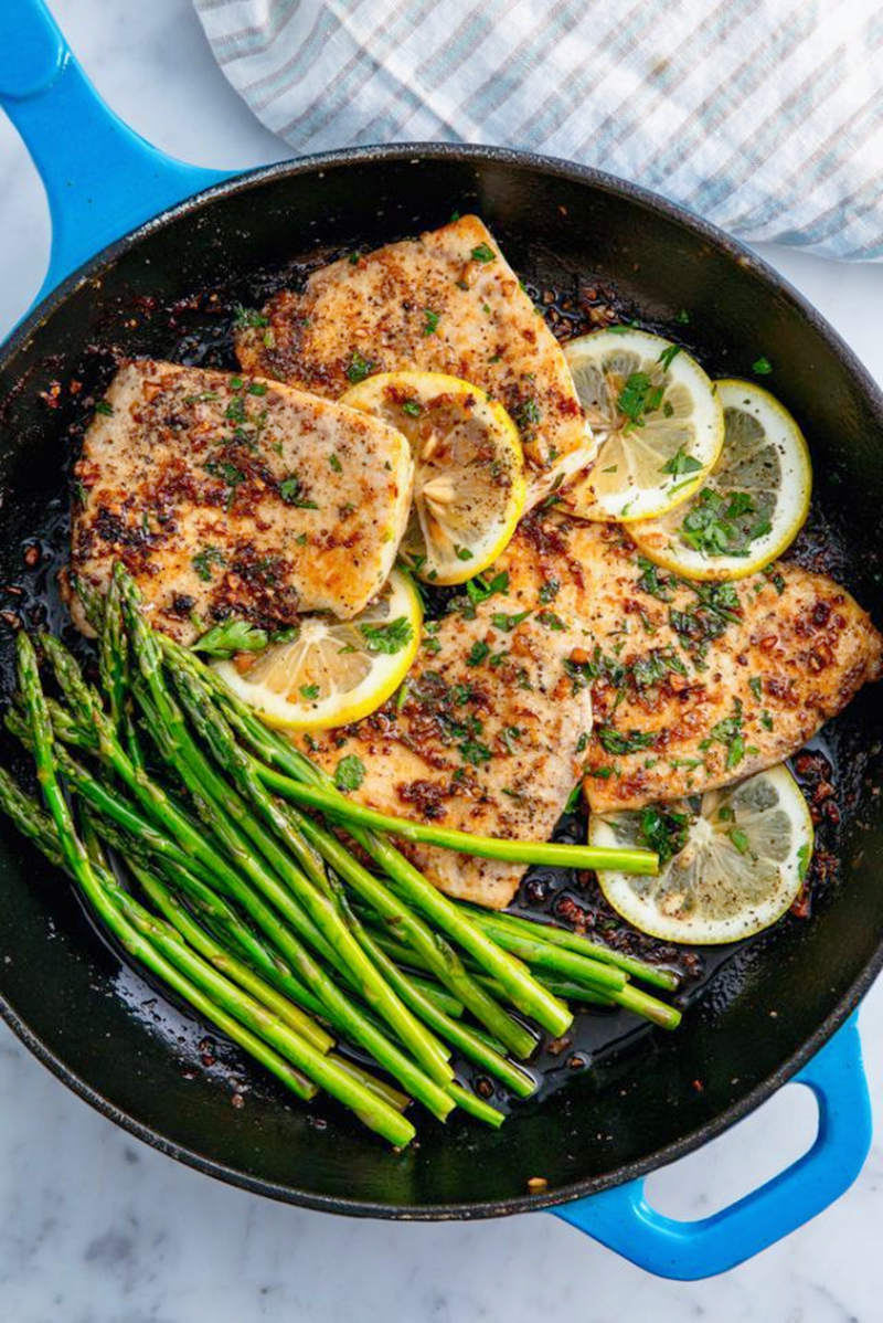 _*Garlicky Lemon Mahi-Mahi*_ /If you haven’t tried mahi mahi, you really need to get on that. It’s a firm, mild fish that, when cooked, is beautifully flaky and tender. It’s also super versatile—you can bake, sear, grill, or fry it and top it with any number of different sauces or dressings. Our favorite way to prep it? Cook it on the stove with some fresh asparagus, and then smother it in a lemony butter sauce. ]/ /How do I buy mahi mahi?/ /Mahi Mahi is often sold skinless, in pre-portioned fillets or steaks. The flesh should be firm and pinkish-beige in color. Any darker spots will taste a bit stronger and may be trimmed away. And if your mahi mahi happens to still be wearing its gorgeous gold and yellow skin, you’ll definitely want to remove that before cooking./  /What if I can’t find it?  If you can’t find mahi mahi but still want to make this recipe, you can substitute another firm white fish, such as cod, striped bass, or halibut. Though to be honest, if you’re buying halibut, we’d highly recommend our easy grilled halibut with mango salsa - it’s a winner./  /Is it hard to cook? Not at all. This easy recipe comes together in less than 30 minutes. Just add the fish to the pan, cook it for a few minutes per side, and then make a super simple garlicky lemon butter sauce in the same pan. We like to cook up a little asparagus too, but it’s not necessary. / /What if my fish sticks in the pan? Don’t panic. Fish can occasionally stick when you’re cooking it, but there are a few sure-fire tricks to make sure that doesn’t happen. First, pat your fish dry on both sides before you put it in the pan. Second, make sure the pan is really hot before you add the fish. You don’t want it to be smoking, but it should definitely sizzle when the fish hits the pan. Finally, let the fish cook for at least 3 minutes before you try to flip it. It will release from the pan when it’s ready, so if it’s sticking, give it another minute and then try again./ /What should I serve with my fish? Anything you want. We love pairing it with some extra lemon wedges, a savory roasted green (such as asparagus or string beans) and some ultra creamy mashed potatoes./ /Need more convincing? We didn’t think so. Read on for more top tips on making the mahi mahi of your dreams . . . and let us know what you think in the comments below.   Looking for more delicious fish recipes? Check out more of our favorite seafood recipes here.  / /This recipe was updated on May 15, 2022, to include more information. /   #GrilledHalibut #Asparagus #StringBeans #CreamyMashedPotatoes #FavoriteSeafoodRecipes  YIELDS: 4 serving(s) TOTAL TIME: 30 mins PREP TIME: 10 mins Ingredients:  3 tbsp. butter, divided 2 tbsp. extra-virgin olive oil, divided 4 (4-oz.) mahi-mahi fillets Kosher salt Freshly ground black pepper 1 lb. asparagus 3 cloves garlic, minced 1/4 tsp. crushed red pepper flakes 1 lemon, sliced Zest and juice of 1 lemon 1 tbsp. freshly chopped parsley, plus more for garnish See All Nutritional Information  Directions: Step 1 In a large skillet over medium heat, melt 1 tablespoon each of butter and olive oil. Add mahi-mahi and season with salt and pepper. Cook until golden, 4 to 5 minutes per side. Transfer to a plate.  Step 2 To skillet, add remaining 1 tablespoon oil. Add asparagus and cook until tender, 2 to 4 minutes. Season with salt and pepper and transfer to a plate.  Step 3 To skillet, add remaining 2 tablespoons butter. Once melted, add garlic and red pepper flakes and cook until fragrant, 1 minute, then stir in lemon, zest, juice, and parsley. Remove from heat, then return mahi-mahi and asparagus to skillet and spoon over sauce.  Step 4 Garnish with more parsley before serving.