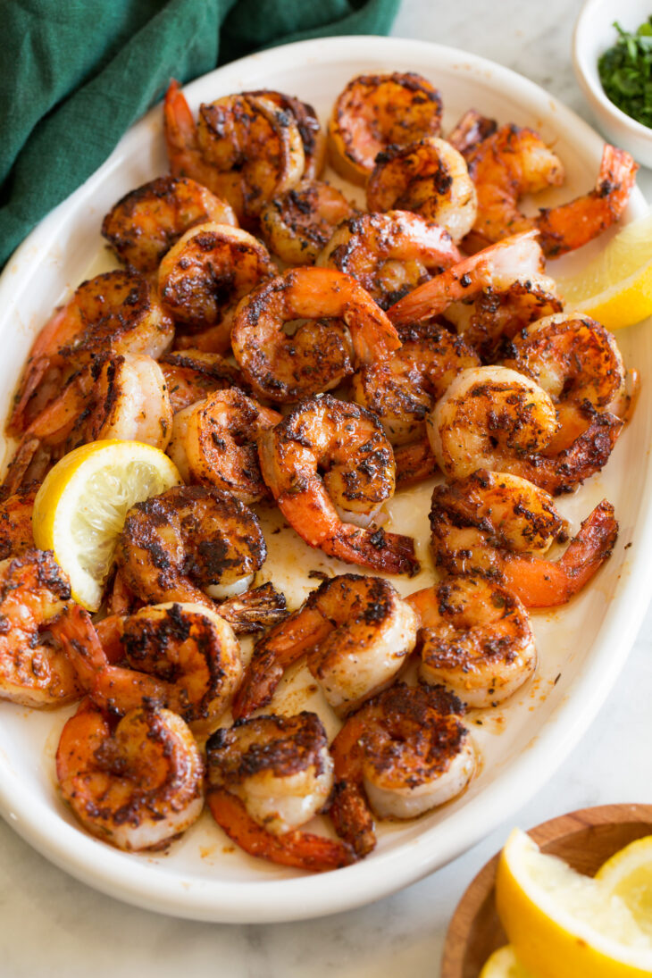_*Blackened Shrimp*_ /Flavorful Blackened Shrimp – A cajun dish made with savory shrimp generously coated with a spicy blackened seasoning and pan fried in a hot skillet until lightly charred. Then to highlight them they’re drizzled with melted butter for a rich enhanced finish./   #Healthy #MainDish #Seafood #Butter #CayennePepper #GarlicPowder #Lemons #OnionPowder #Paprika #Pepper #Shrimp #Sugar  Prep: 15 minutes. Cook: 3 minutes. Ready in: 18 minutes.  Ingredients: 1: 18 oz. extra large shrimp (about 24), peeled and deveined*. 2: 1 1/2 tsp paprika. 3: 1 1/2 tsp granulated sugar. 4: 1/2 tsp ground black pepper, or to taste. 5: 1/2 tsp cayenne pepper, or to taste (this is spicy). 6: 1/2 tsp garlic powder. 7: 1/2 tsp dried thyme. 8: 1/2 tsp dried oregano. 9: 1/4 tsp onion powder. 10: Salt, to taste. 11: 1 1/2 Tbsp light olive oil** or vegetable oil. 12: 2 Tbsp butter, melted. 13: 1/2 lemon cut into wedges, for serving. 14: 1 Tbsp chopped fresh parsley (optional), for garnish.  Instructions: 1: Place shrimp on a cutting board or large plate. If shrimp are very wet dab up some of the excess moisture with paper towels. 2: In a mixing bowl whisk together paprika, sugar, black pepper, cayenne pepper, garlic powder, thyme, oregano, onion powder, and salt to taste. 3: Heat a cast iron skillet over medium-high heat for about 5 minutes. 4: Meanwhile scoot shrimp very close together but don't overlap them. Sprinkle half of the spice mixture evenly over the shrimp, then turn shrimp and evenly sprinkle opposite side with remaining half of spice mixture. 5: Pour light olive oil into skillet and using hot pads carefully tilt oil in pan to coat. 6: Add the shrimp and immediately scoot into a single layer. Let cook about 1 to 1 1/2 minutes until lightly charred then quickly turn shrimp and cook opposite side until shrimp are just cooked through about 1 minute (they should become just opaque throughout). 7: Immediately transfer to a serving platter so they don't continue to cook. 8: Pour butter over shrimp. Garnish with parsley if desired. Serve with lemon wedges for spritzing. Notes: *Shrimp tails can be left on or removed. *Don't use extra virgin or even regular olive oil. Light olive oil has a high smoke point and is better for cooking at this temperature. 1 lime can be substituted for the lemon and cilantro can be substituted for parsley.  