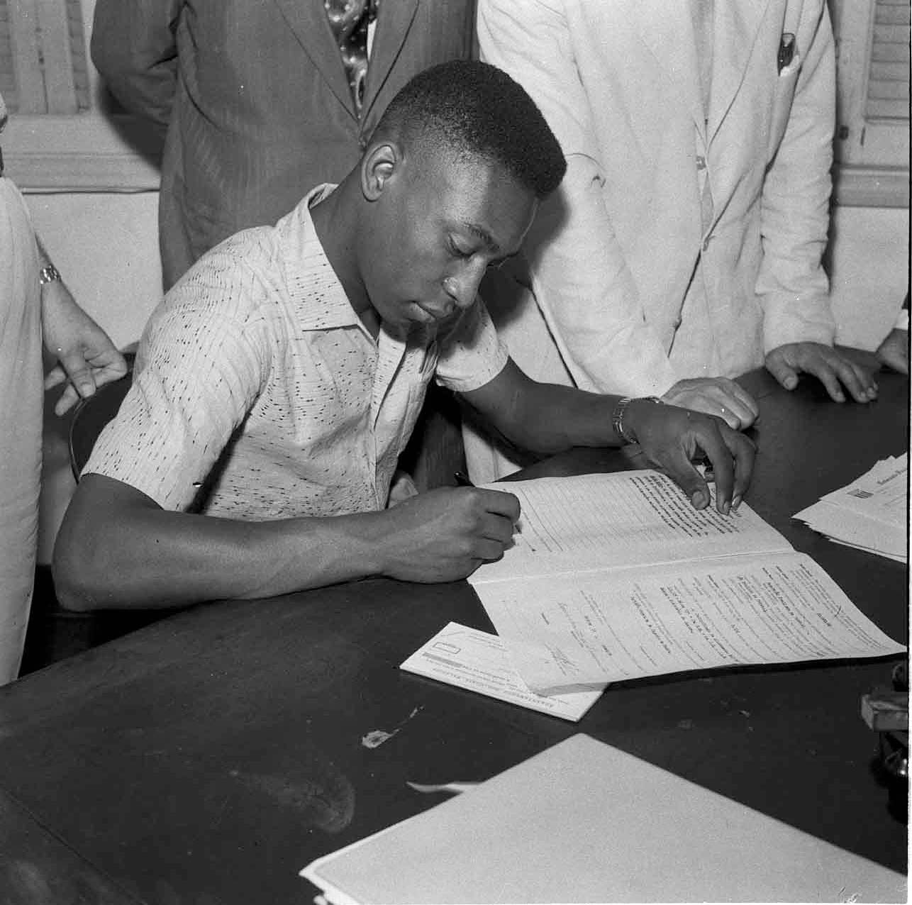 Em 1957, Edson assinava seu primeiro contrato profissional com o @SantosFC. Isso aconteceu depois de o menino impressionar o treinador, Lu&iacute;s Alonso P&eacute;rez (Lula), ap&oacute;s atuar em 30 partidas como atleta amador pelo clube. O ex-jogador da Sele&ccedil;&atilde;o Brasileira, Waldemar de Britto, foi quem levou Pel&eacute; para fazer testes na Baixada Santista. Era o in&iacute;cio de uma grande hist&oacute;ria. O Rei fez 1363 partidas, sendo 1116 pelo Santos, e marcou 1282 gols, 1091 com a camisa alvinegra.
.
In 1957, &hellip; See more
  @Pele